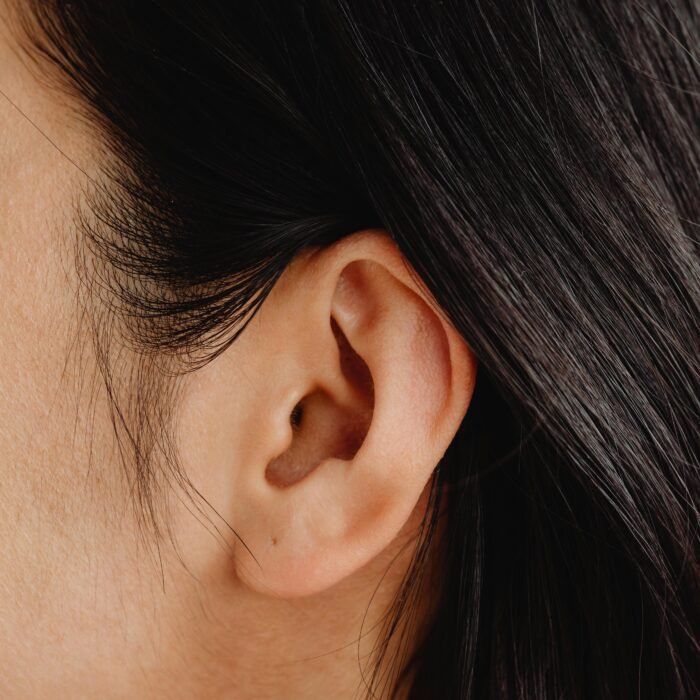 Detailed close-up image showcasing a human ear and dark hair.